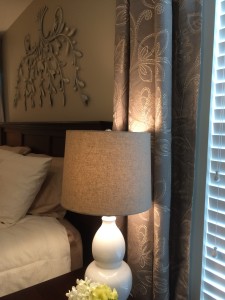 Cream lamp and curtain panel by bedside